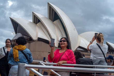 澳洲已暫停「黃金簽證」的申請。圖為觀光客在雪梨歌劇院前拍照。 歐新社