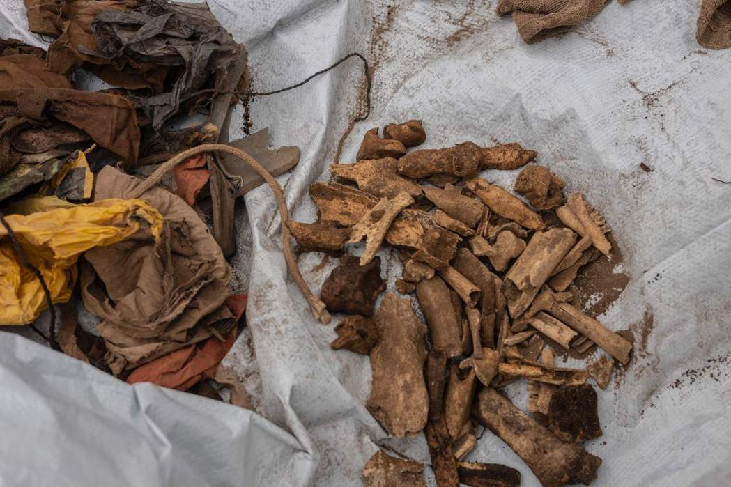 盧安達新挖出的大屠殺受害者遺骨。挖掘志工協助依照骨頭部位分類清點。 圖／法新社