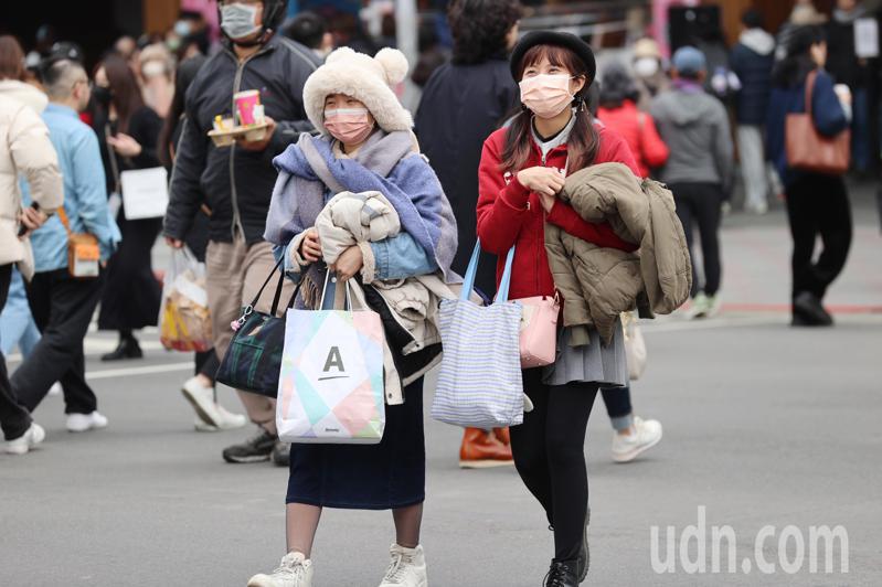 寒流低溫影響台灣逐漸減弱，台北民眾週末假期手上拿著厚外套外出逛街。記者林伯東／攝影