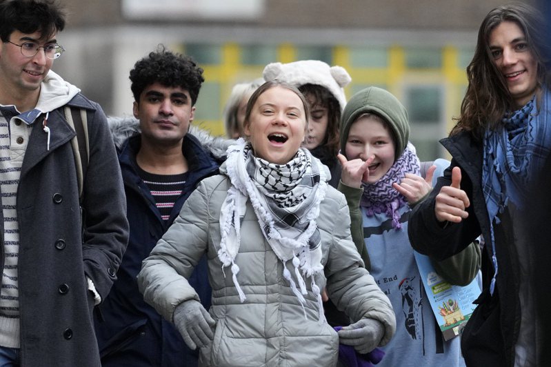 瑞典環保少女童貝里2日與其他抗議者抵達倫敦西敏地方法院時笑開懷。美聯社