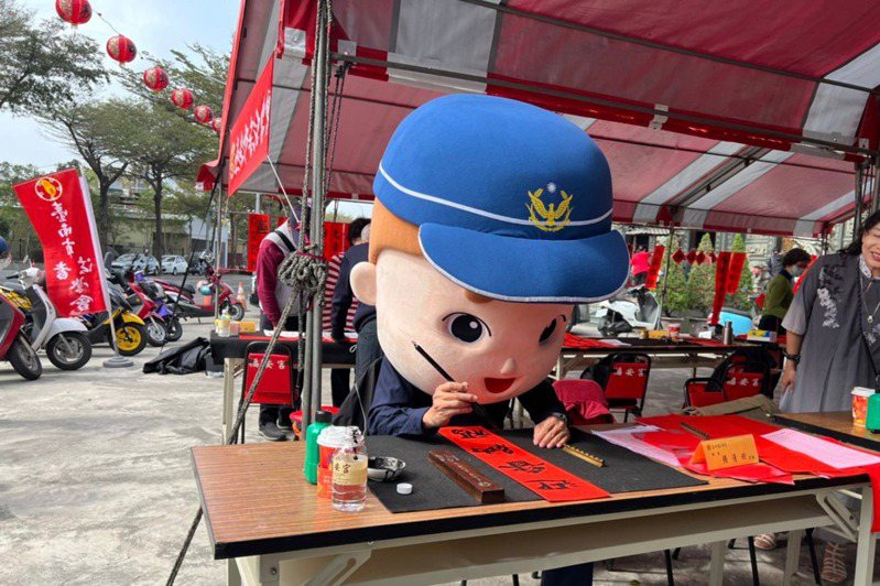 警察大頭寶寶在台南市北區鄭子寮福安宮前寫春聯，可愛的模樣，逗得現場民眾開懷大笑。記者黃宣翰／翻攝
