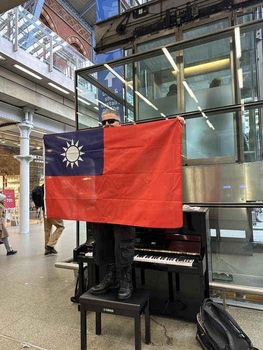 英國鋼琴家卡瓦納5日在其社群媒體臉書網頁，貼出1張他站在鋼琴椅上雙手攤開我國國旗的圖片。擷自X