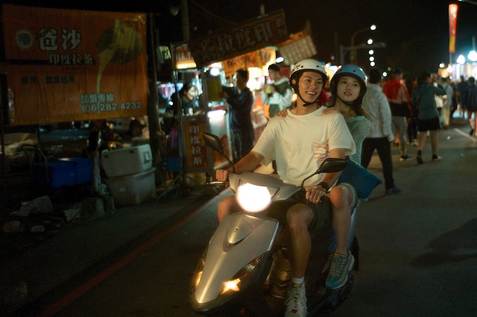 許光漢（左）與清原果耶騎車經過夜市，浪漫又平實。圖／翻滾吧男孩電影有限公司提供