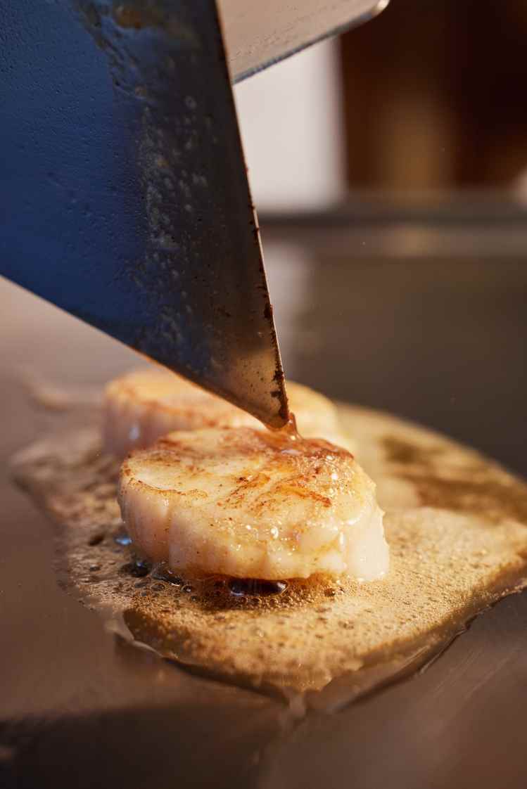 蘸取小麥粉在平底鍋，以奶油反覆煎煮干貝至焦糖般金黃色，就是最簡單的香煎法。圖／日本貿易振興機構提供