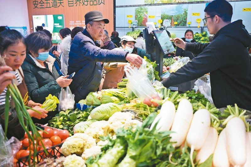大陸國家統計局八日公布一月份相關經濟運行數據。圖為江蘇南京市民在一家農貿市場內購買蔬菜。（中新社）
