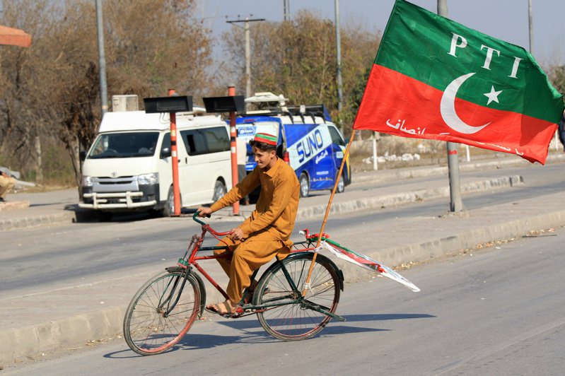 巴基斯坦全國大選大勢底定，未有單一政黨在下議院取得過半數席位，主要政黨已開始協商籌組聯合政府。圖為一名巴基斯坦正義運動黨(PTI) 的支持者在腳踏車上掛起黨旗。歐新社