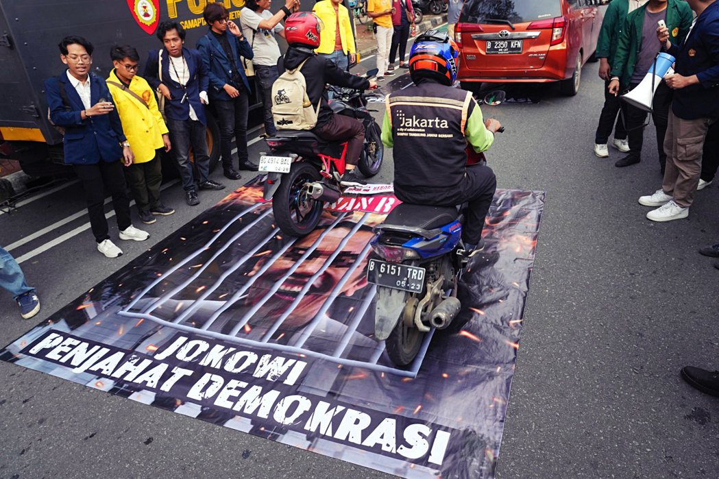 2024 年 2 月，在印尼的選舉委員會大樓外，民眾舉行示威抗議、製作印著佐科威...