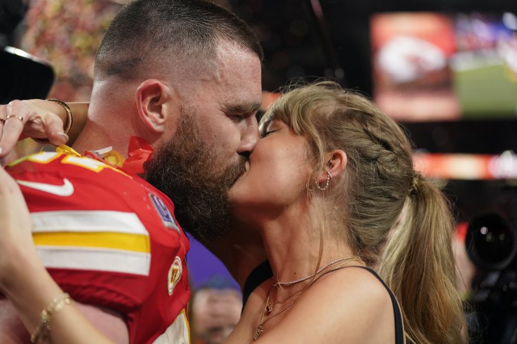 泰勒絲(右)在超級盃賽後擁吻拿下冠軍的男友崔維斯凱爾西，引爆話題。（美聯社）