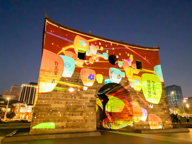 光雕展演「北門映像」首次加入互動式體驗，民眾透過手機掃描QR_Code，便能將新年期許和祝福投影在北門上。北市觀傳局提供
