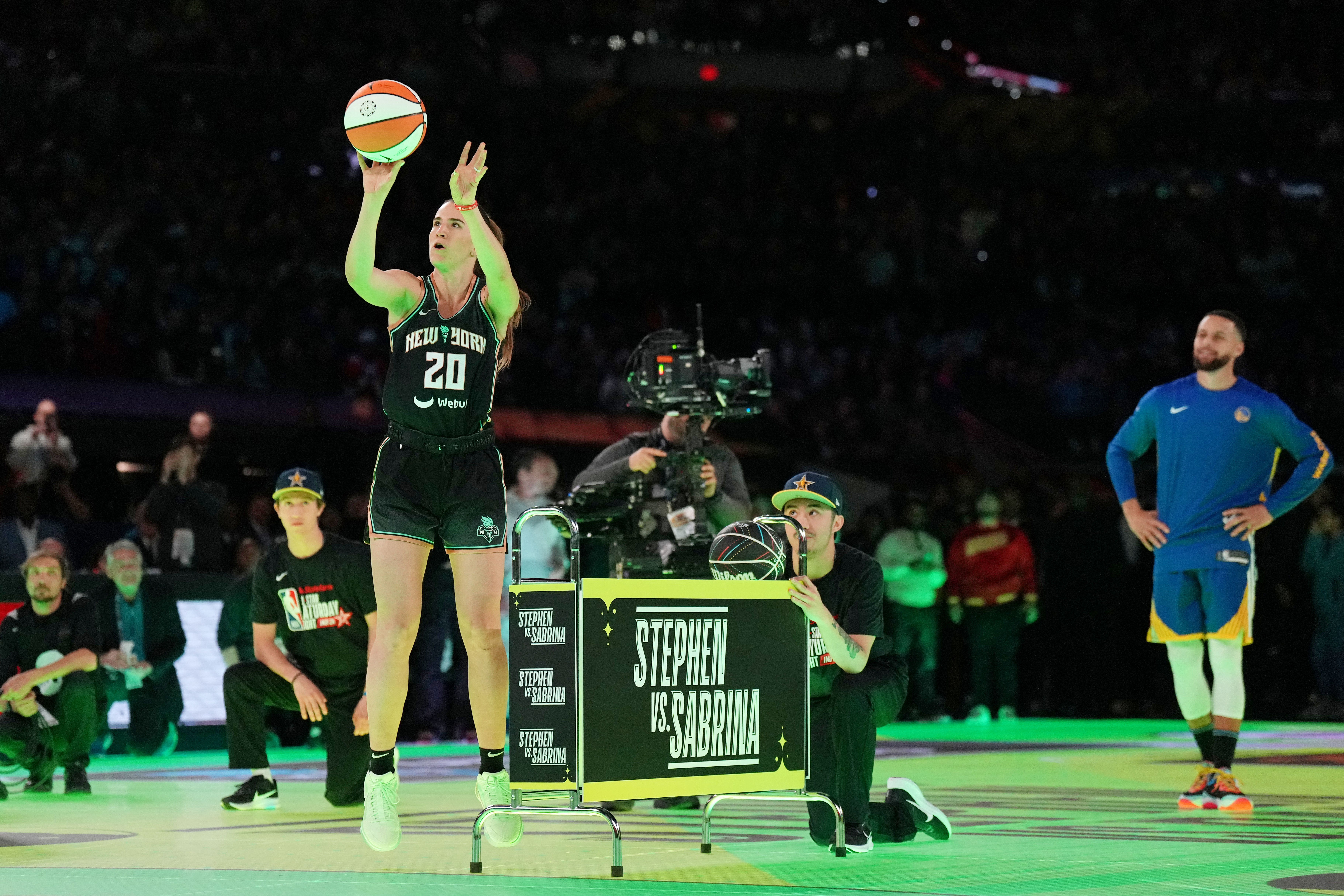 WNBA球星優涅思庫（左）大秀三分球功力，柯瑞（右）站在一旁仔細欣賞。（路透）