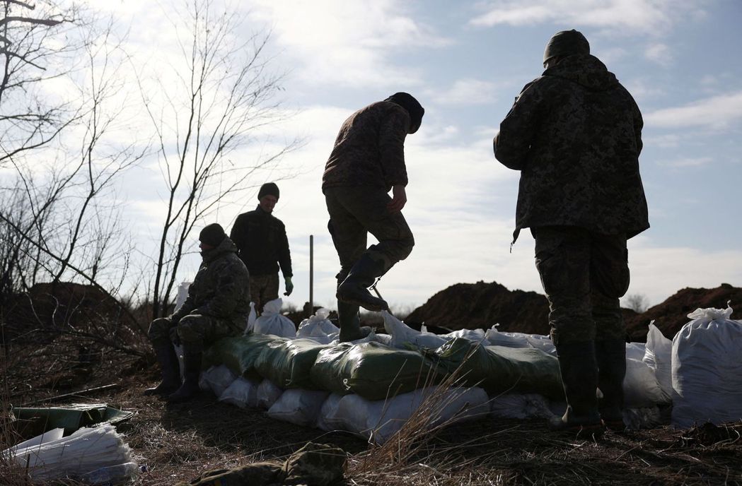 阿夫迪夫卡鄰近村莊，2月17日烏克蘭軍人還在進行防禦準備，圖為軍人堆疊沙袋。 圖...