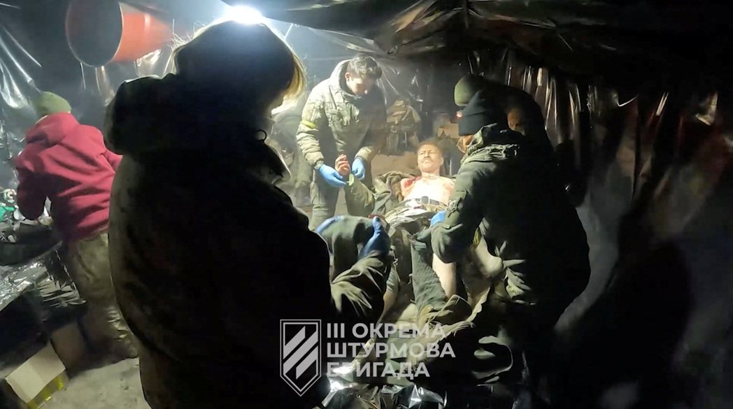 烏克蘭軍隊宣布從阿夫迪夫卡撤退。圖為烏軍16日釋出的影片，軍人正在救治傷兵。 圖...