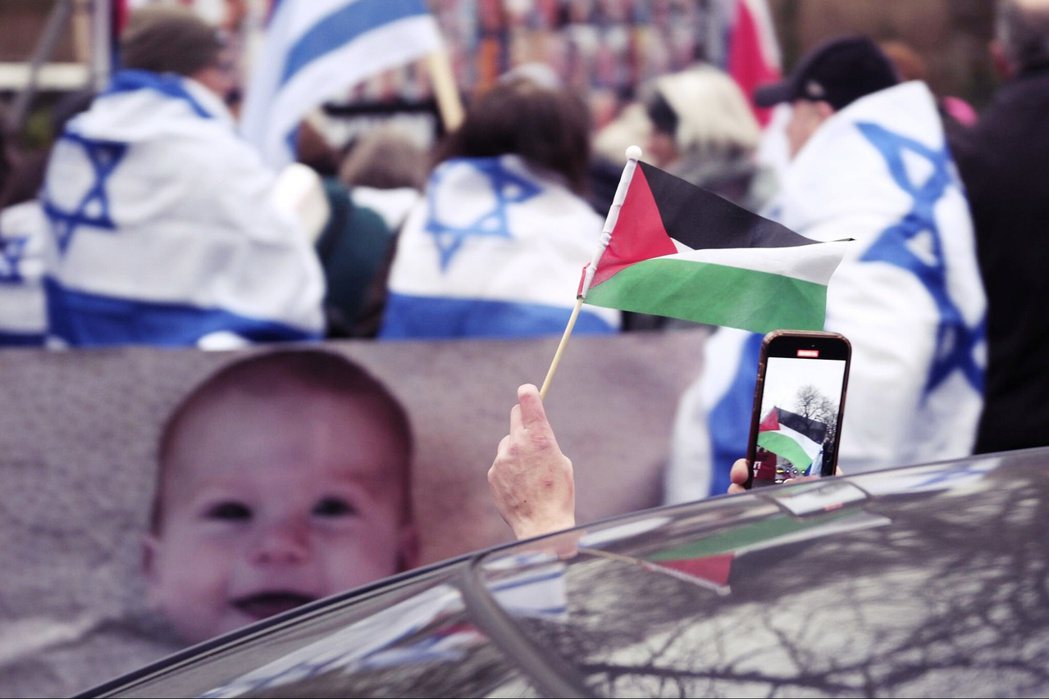 2024年1月12日，一名支持巴勒斯坦的民眾在經過海牙國際法院外的聲援以色列活動...