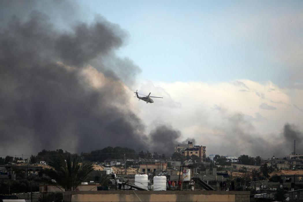 以色列直升機飛過遭轟炸的加薩上空。 圖／美聯社　