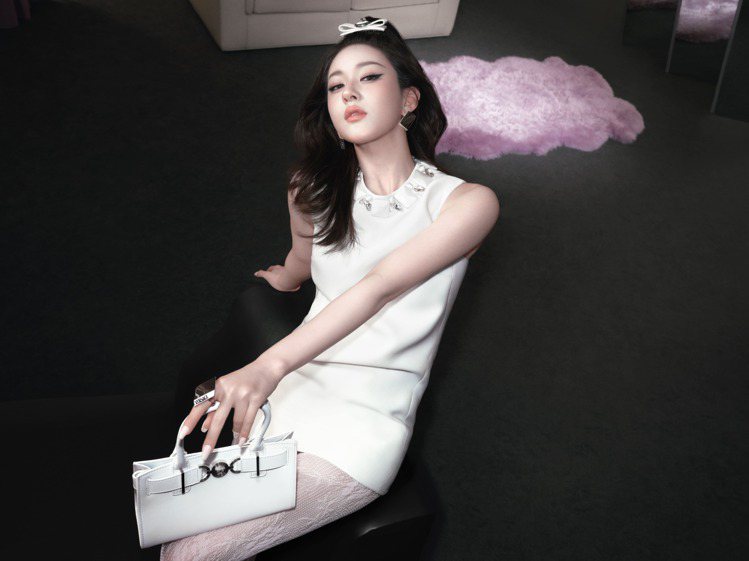 Versace全球品牌大使趙露思個性演繹Versace 2024春夏系列，穿飾有刺繡項鍊的緞面迷你洋裝，搭配Medusa '95手提包。圖／凡賽斯提供