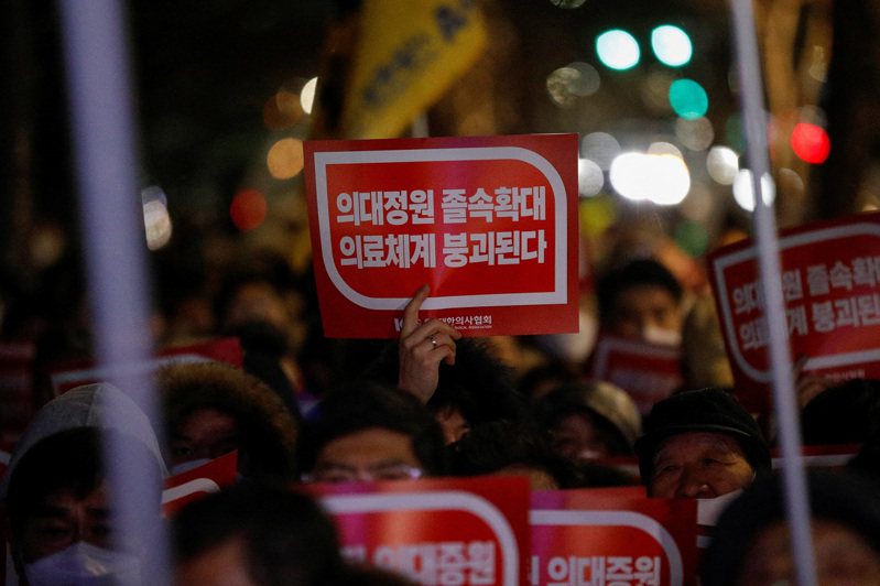 南韓醫界反對政府計畫增額錄取2000名醫學院學生，數千名實習和住院醫師20日起集體請辭罷工。圖為一名醫師22日在首爾總統府前舉標語抗議。路透