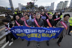南韓醫師舉布條走向總統室，要求停止擴增醫學系招生名額。美聯社