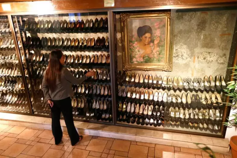 伊美黛逃亡時遺留在官邸的三千雙鞋，2012年於菲律賓馬里基納市鞋子博物館展出，牆上是伊美黛年輕時的畫像。圖／美聯社