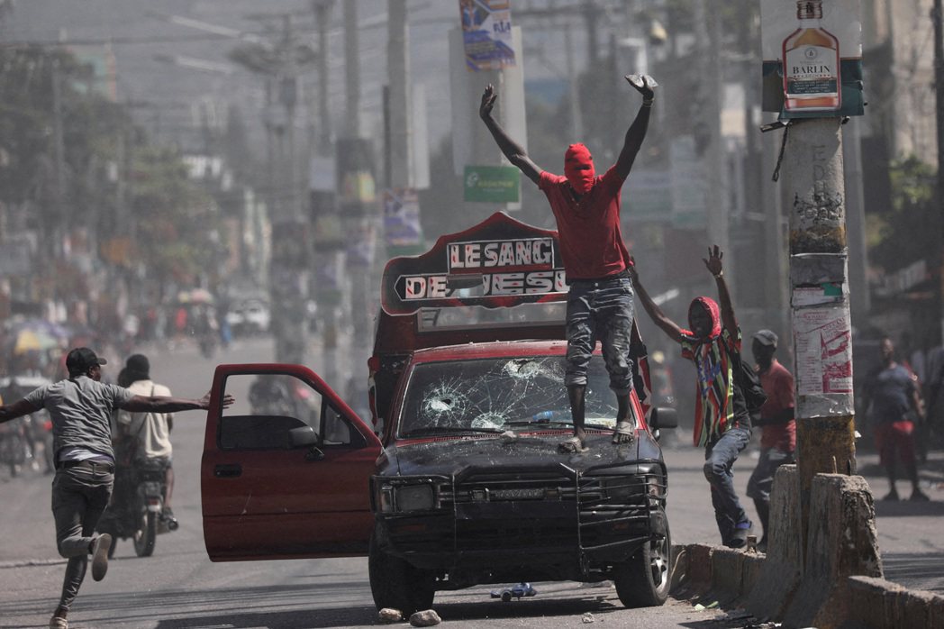 2024年3月1日，海地太子港，一名蒙面男子呼籲示威者停止抗爭。 圖／路透社