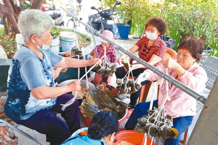 國泰人壽小港通訊處員工在去年端午節擔任「包粽子趣味競賽」的志工，帶著社區的長輩、弱勢家庭一起包粽子，感受端午節氣氛。 國泰人壽／提供