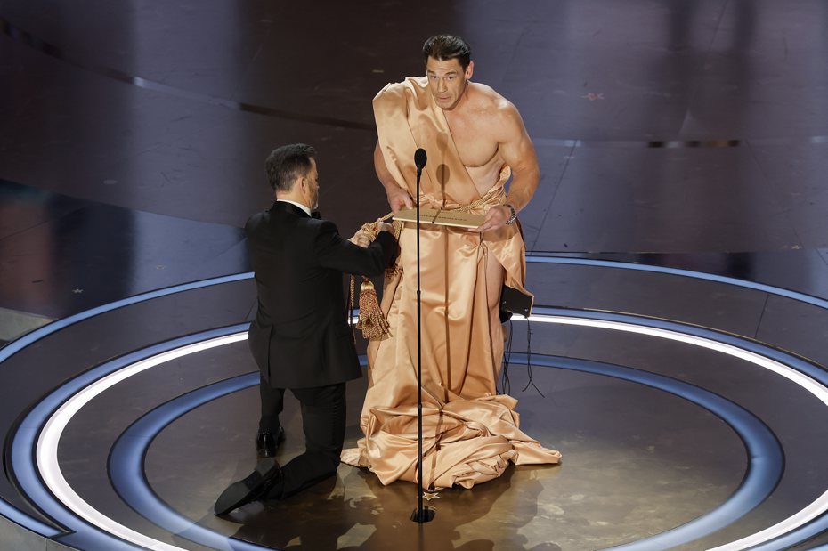 約翰希南(右)在奧斯卡頒獎典禮上近乎全裸頒獎，主持人吉米金莫證實兩人為了該橋段開會多次，就是怕約翰走光。(歐新社)
