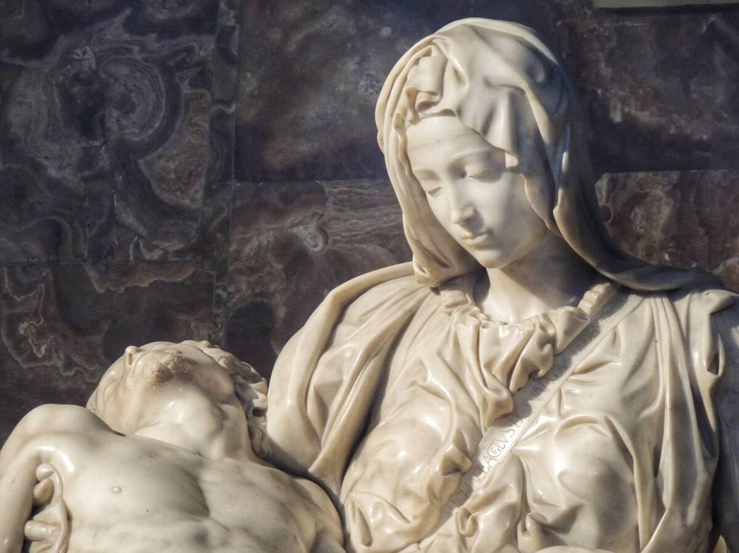 瑪利亞胸前自左肩斜垂而下的衣帶，刻著一行字「佛羅倫斯人米開朗基羅·博納羅蒂所作」...