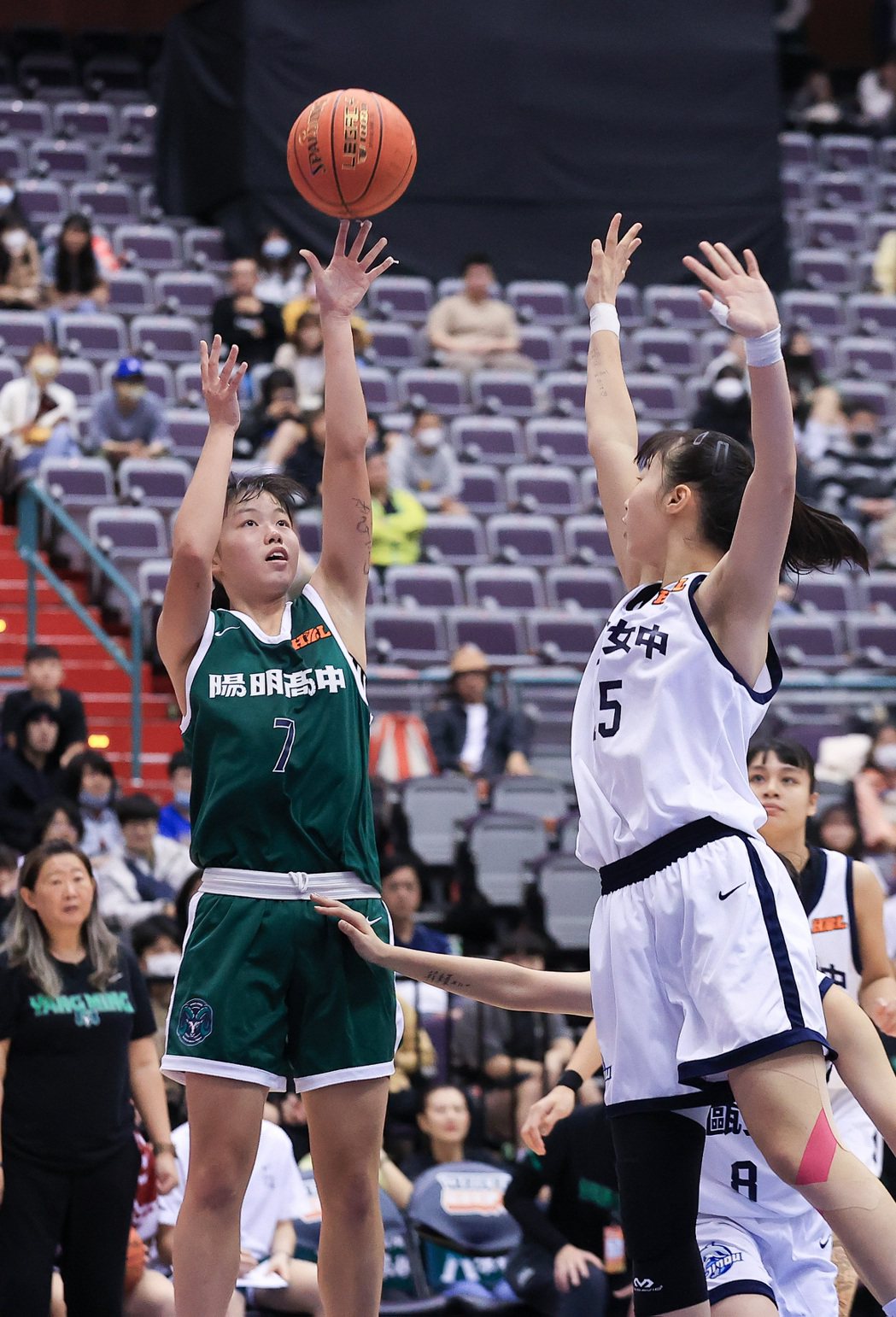 HBL高中籃球聯賽女子組季軍戰，陽明高中許語珊（左）閃過防守在籃下投進兩分。記者
