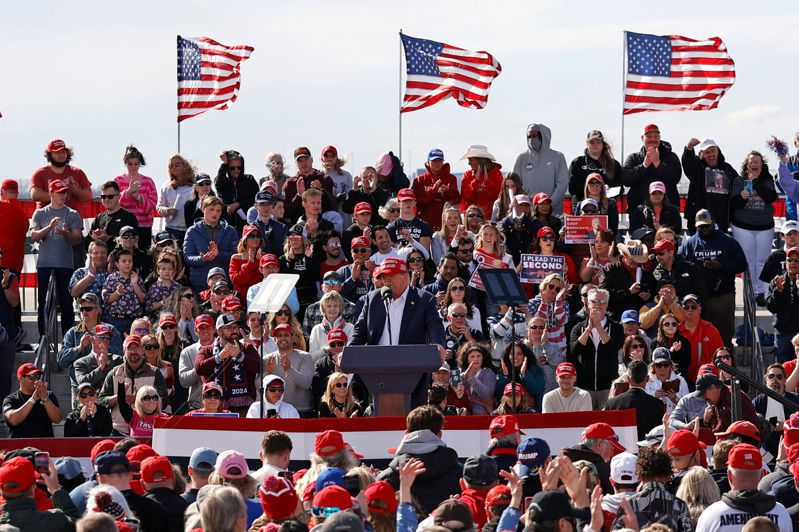 美國前總統川普（中）十六日到俄亥俄州萬達利亞辦選舉造勢活動，對支持者發表演說，背景可見多幅美國國旗和共和黨的代表色紅色。（法新社）
