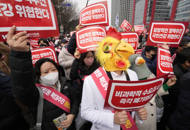 南韓政府今天表示，下周起將正式對未回到工作崗位的罷工醫師實施扣留執照處分。圖為日前一名戴著口罩的醫生參加反對政府醫療政策的街頭抗議。（美聯社資料照片）