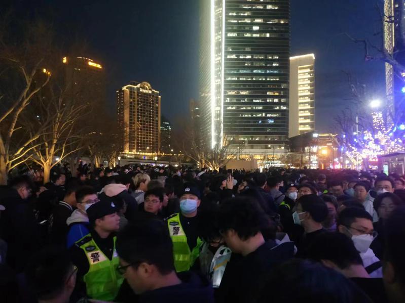 21日晚間18時左右，靜安廣場已擠進慢慢人潮，上海警察為了控管人流量，也拉起層層封鎖線。而排隊民眾要能靠近蘋果店所在的下沉廣場十分困難。記者黃雅慧／攝影