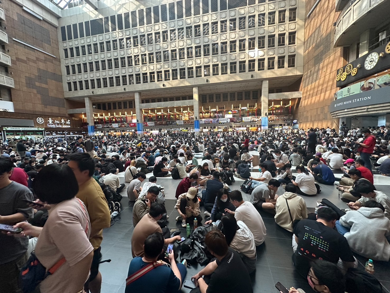 台北車站大廳今天下午出現許多寶可夢玩家，因今天為神獸「原始固拉多」團體戰日，百餘名玩家席地而坐擠滿大廳直接抓寶。 圖／讀者提供
