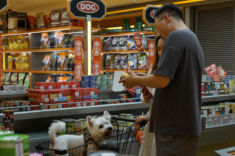 中國大陸「牠經濟」正在快速崛起，圖為北京市朝陽區一家寵物超市裡，寵物主正帶著毛小孩挑選寵物用品。新華社