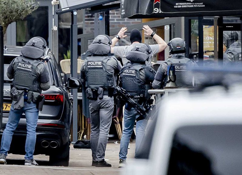 荷蘭東部小鎮埃德當地受歡迎的夜店「襯裙咖啡廳」30日稍早驚傳多人遭脅持。英國天空新聞和路透等多間媒體報導，警方在一名戴著面罩的男子（中）走出夜店後將其上銬逮捕。歐新社