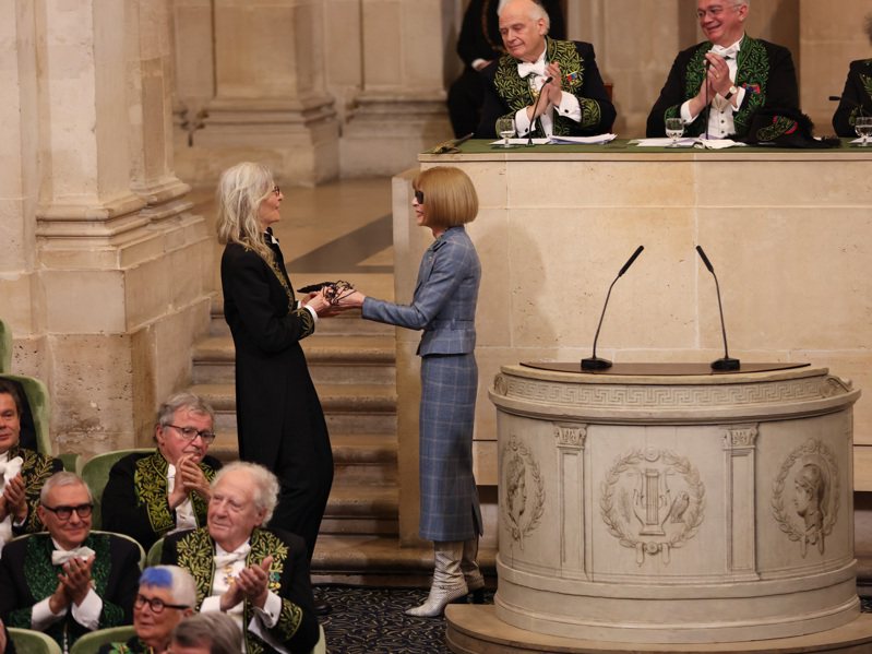 女攝影師Annie Leibovitz（左）於法蘭西藝術院外國院士任命典禮中，自Anna Wintour（右）手中接下院士之劍。圖／Louis Vuitton提供