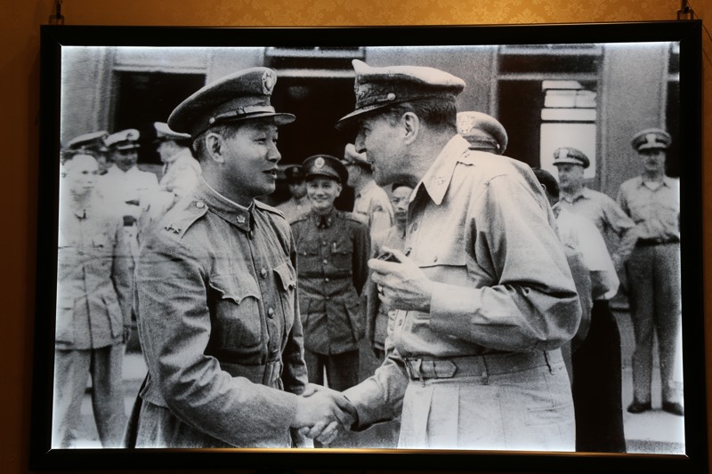 一幅攝於1950年的照片，孫立人（前左）笑著和美國麥克阿瑟將軍（前右）握手寒暄，身後故總統蔣中正（後中）含笑看著這一幕，堪稱孫將軍一生的寫照。圖／羅超群提供