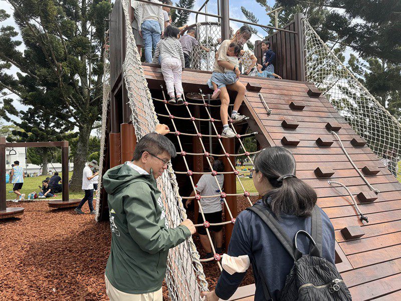 龙潭绿杉林景观公园有的游戏设施，被家长投诉因未分龄幼童使用会有危险，市议员张肇良（左一）要求市府改善。图／张肇良提供