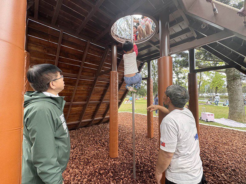 龙潭绿杉林景观公园有的游戏设施，被投诉未分龄幼童使用会有危险，市议员张肇良（左一）要求市府改善。图／张肇良提供