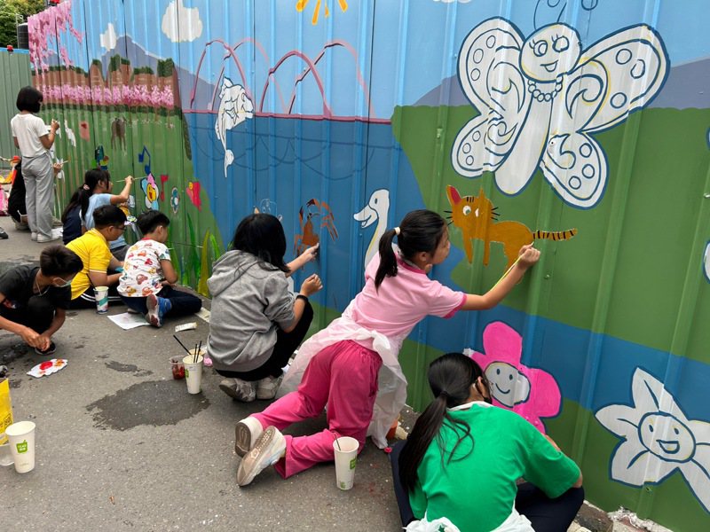 六龟国小师生一同在工地围篱上彩绘当地特色风情。图／高雄市工务局提供