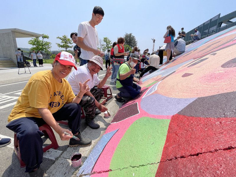 新竹市香山区那鲁湾部落堤防彩绘即将完工，邀请族人一起提笔彩绘。记者张裕珍／摄影