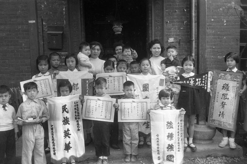 1957年4月6日，中國兒童福利社舉辦的兒童健康比賽及各科兒童天才比賽，當日下午頒獎，會中學童們拿著得獎錦旗合影。圖／聯合報系資料照片