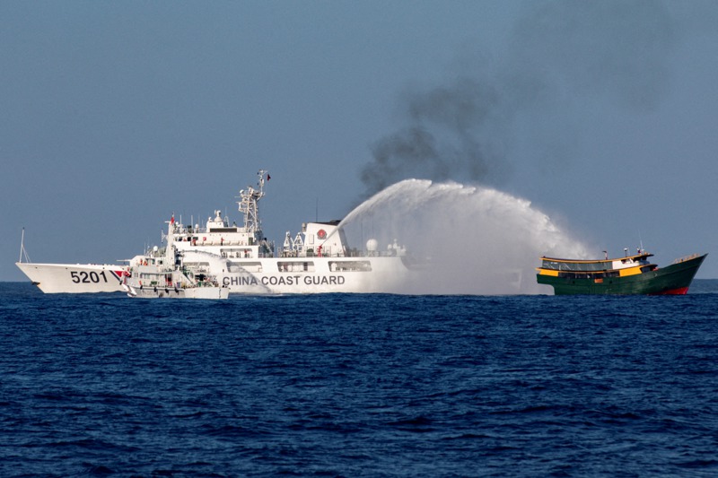 菲律賓海岸防衛隊船隻3月5日在南海執行運補任務時，遭中國海警（左）以水砲襲擊。路透
