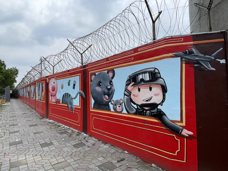 新竹市空军基地旁靠成功路围墙最近完成一大片彩绘，画上以12生肖动物搭铁路小火车的童趣模样，还有军人也画上墙面。记者张裕珍／摄影