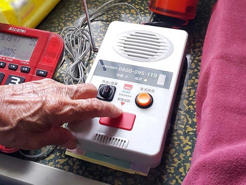 政府針對全國獨居老人設有「緊急救援連線」裝置，簡易裝置讓長者有危險時，能透過按鈕向警消即時求救，也能設定每日報平安。圖／喜憨兒基金會提供
