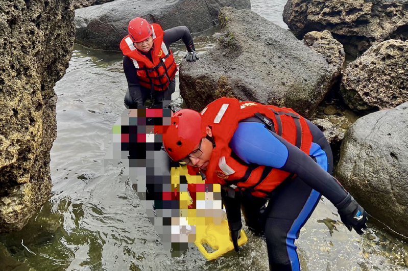 海巡人员将石梯坪游憩区南侧礁岩处的女性浮尸拖回岸上。记者古和纯／翻摄