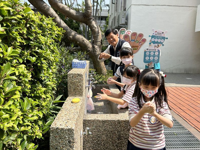 台中市卫生局长曾梓展和学童示范正确洗手五步骤「湿、搓、冲、捧、擦」。记者赵容萱／摄影