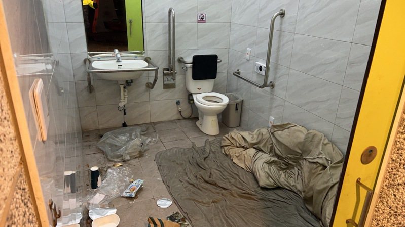 新竹縣竹北市豆子埔公園殘障廁所內有棉被、生活用品和吃完食物，且門遭反鎖，疑似有街友長期占住。圖／民眾提供