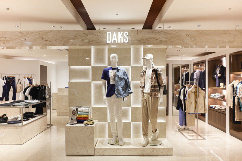 DAKS全台首家全新男装形象柜外观以清新暖调大理石纹为主视觉，内部空间则以温润石材与沉稳木质混搭呈现简约俐落的低调质感，一展品牌年轻化的企图心。图／DAKS提供