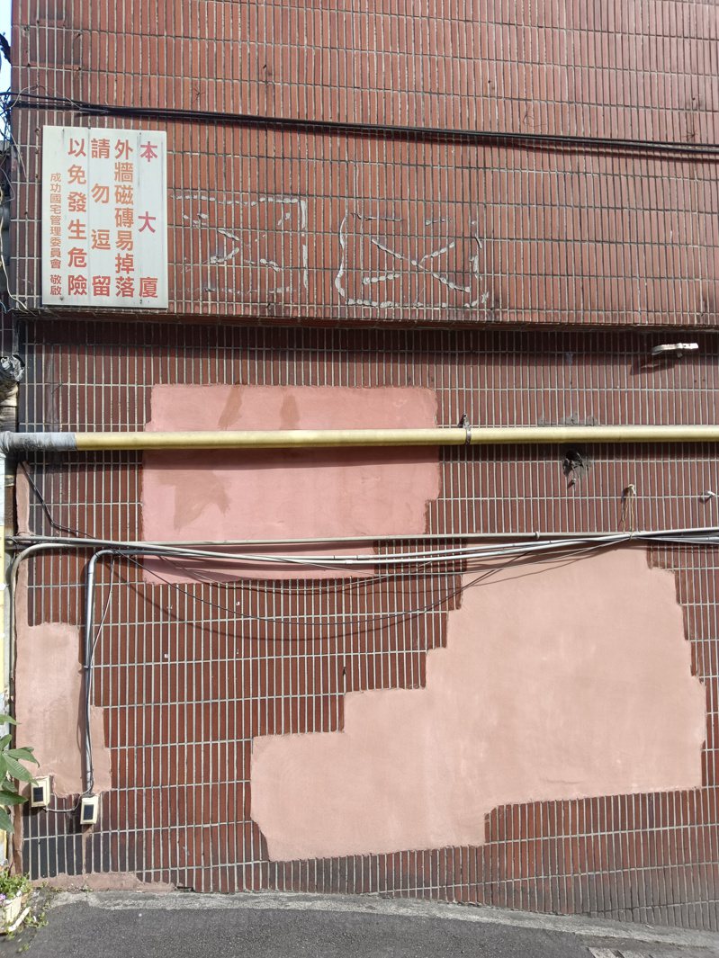 基隆市成功國宅社區外牆多處磁磚剝落後，事後塗抹彈性水泥補救，東一塊、西一塊如「癩痢頭」。記者邱瑞杰／攝影