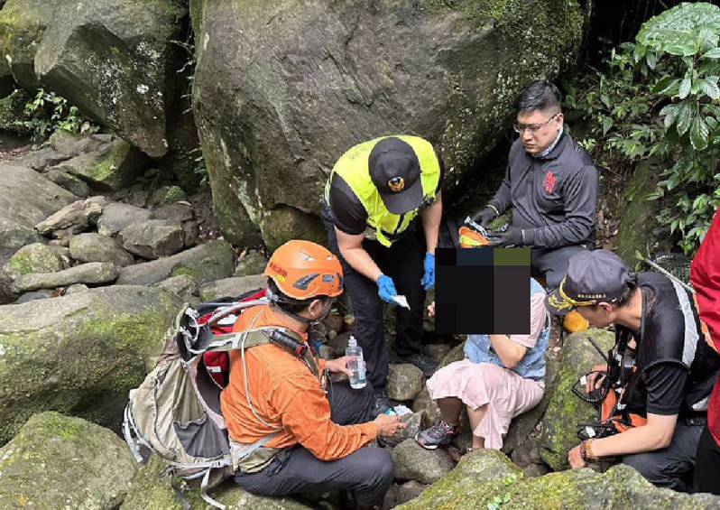 一名女子今天在新北市石门区青山瀑布步道跌倒时，头部撞伤。消防人员包扎止血并协助下山，送医脱险。记者邱瑞杰／翻摄