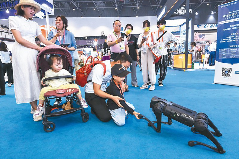 第四屆中國國際消費品博覽會13日在海南海口開幕，圖為參觀者與一款機械狗互動。 （中新社）